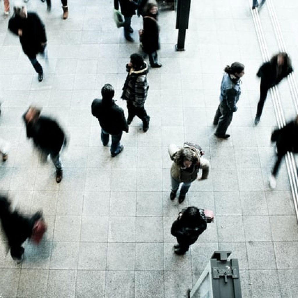 overhead view of blurred people walking through a large lobby